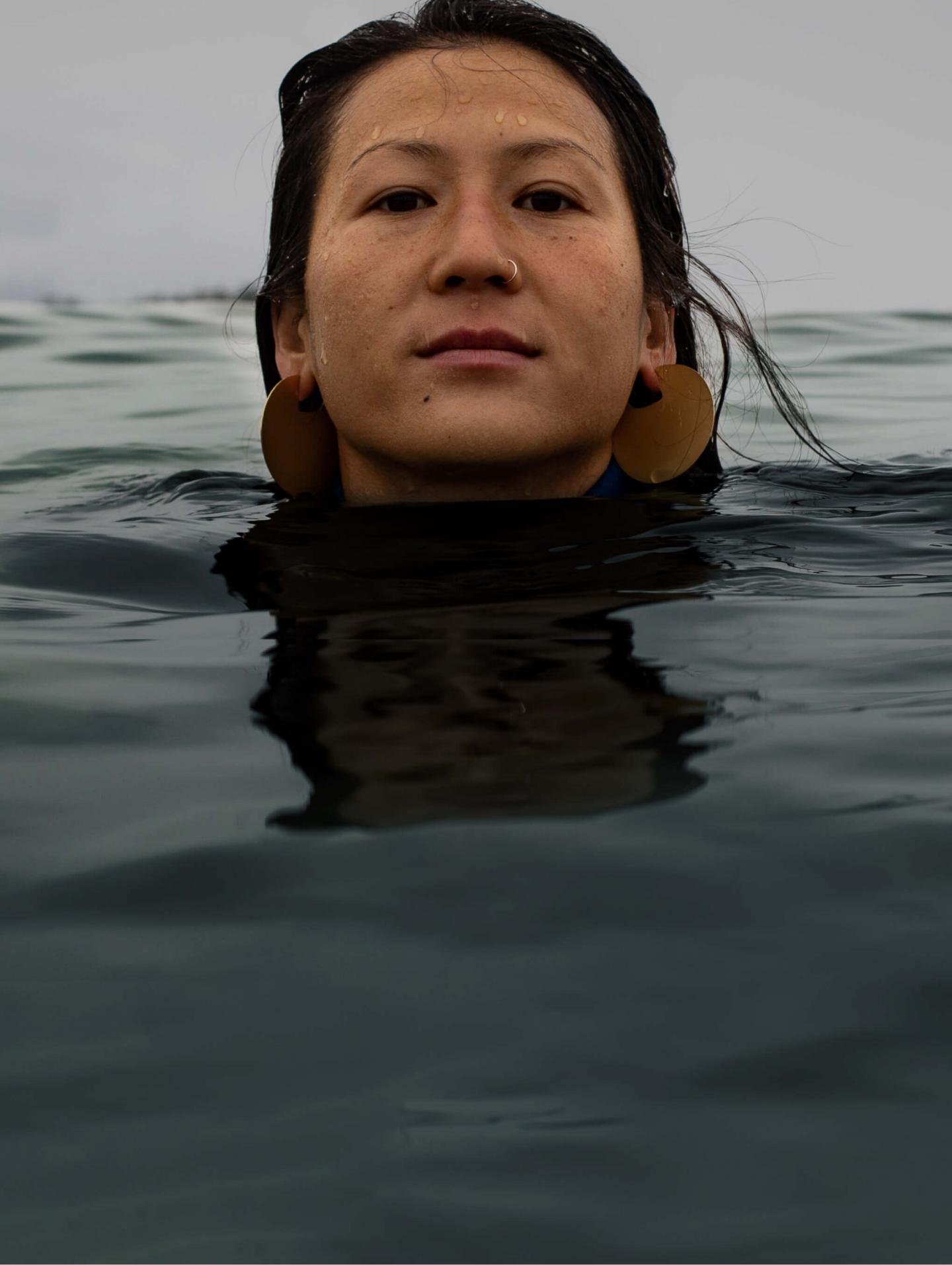 Women with her body submerged in the ocean